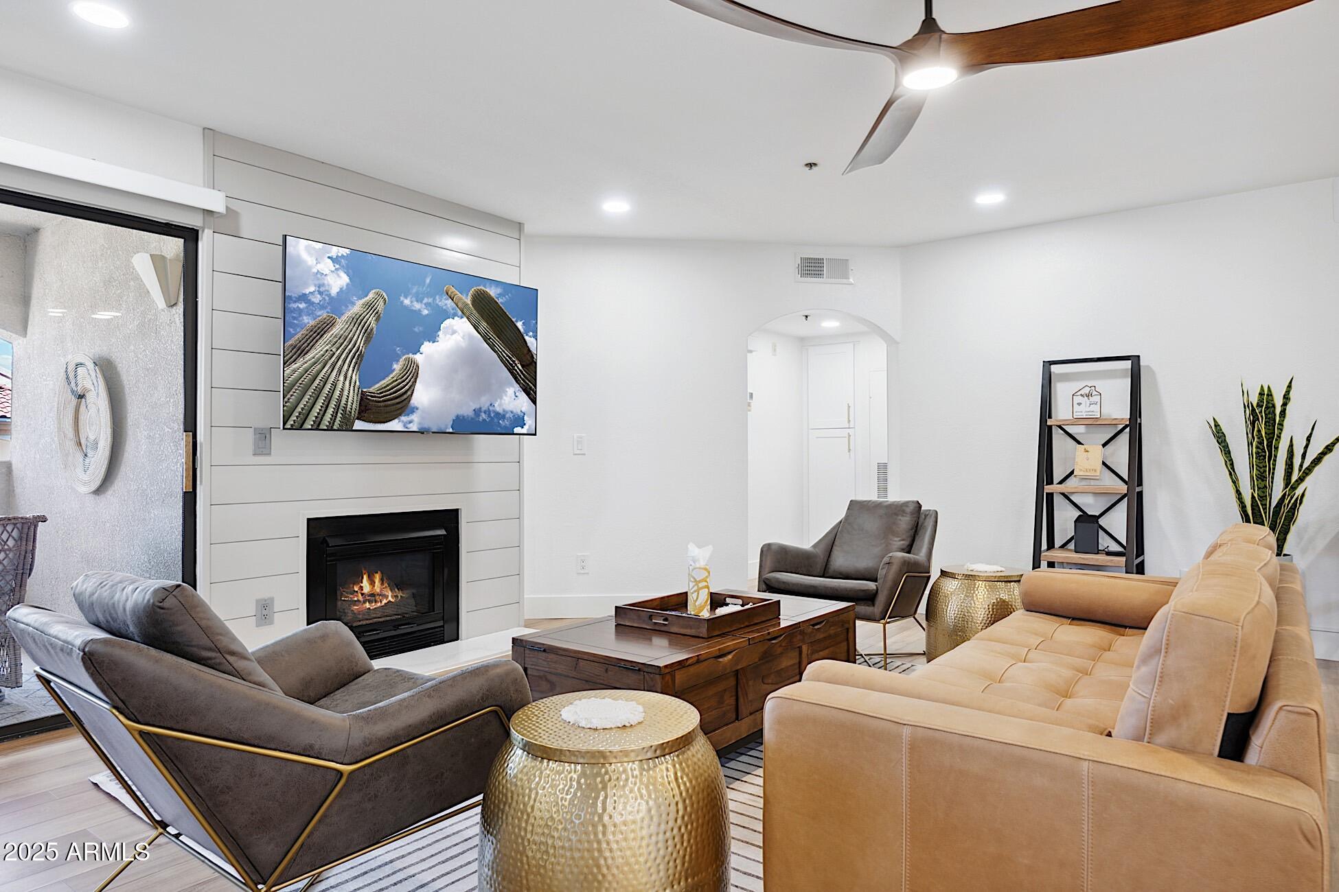 a living room with furniture a fireplace and a flat screen tv