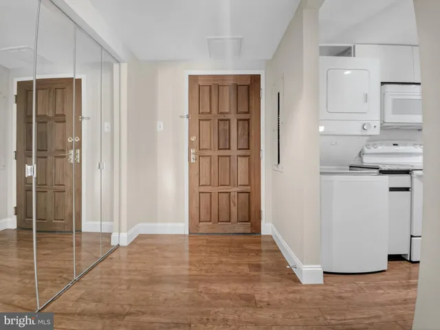 a view of empty room with wooden floor and window