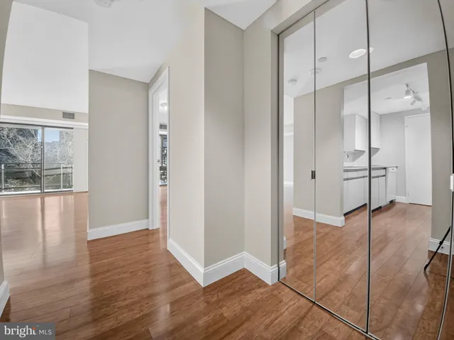 a view of a hallway with wooden floor and staircase