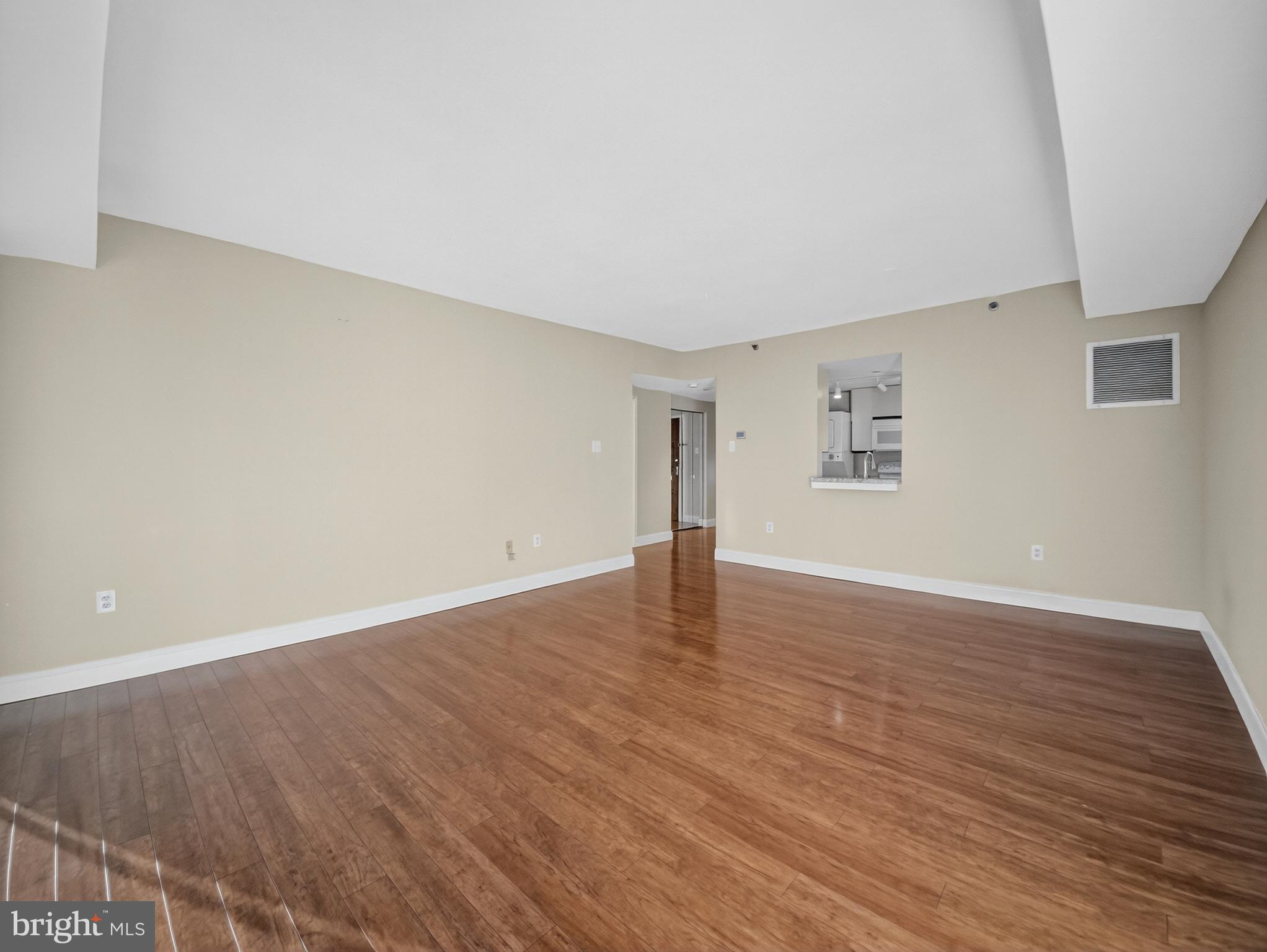 1530 Key Boulevard, Unit 517 Arlington, VA 22209 - Photo 18 of 50 a view of an empty room with wooden floor and a window