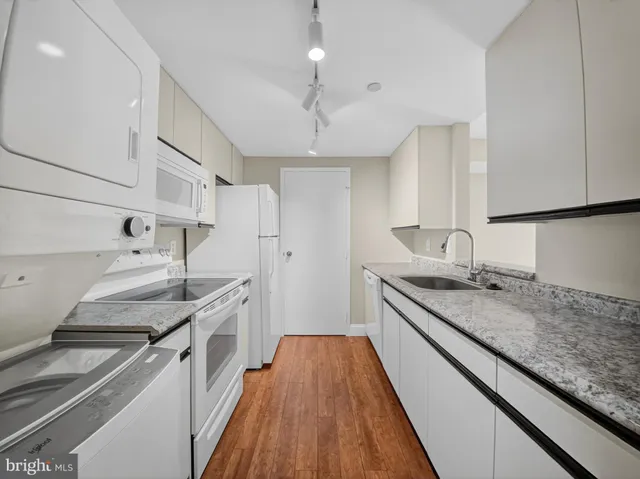 a bathroom with a granite countertop sink and a white cabinets