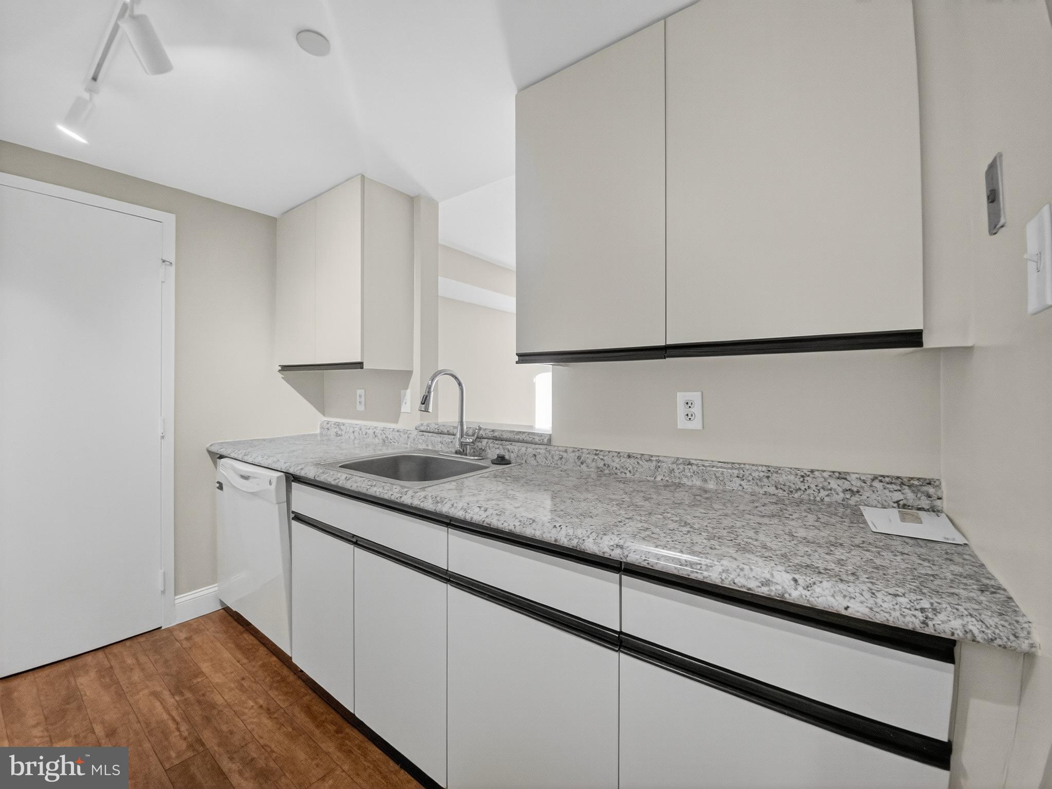 1530 Key Boulevard, Unit 517 Arlington, VA 22209 - Photo 21 of 50 a bathroom with a granite countertop sink and a white cabinets