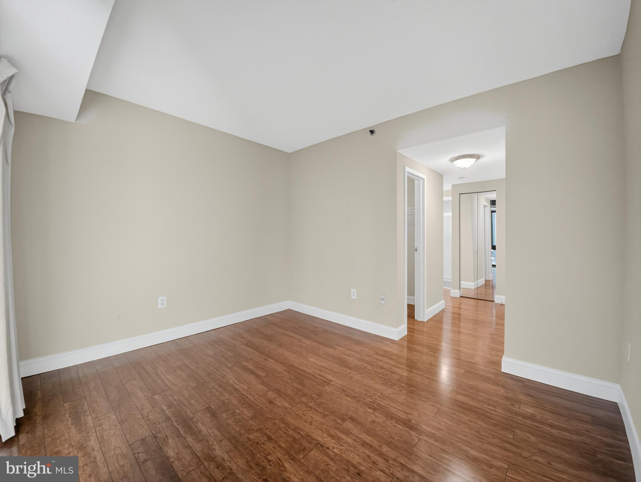 1530 Key Boulevard, Unit 517 Arlington, VA 22209 - Photo 28 of 50 a view of an empty room with wooden floor and a window