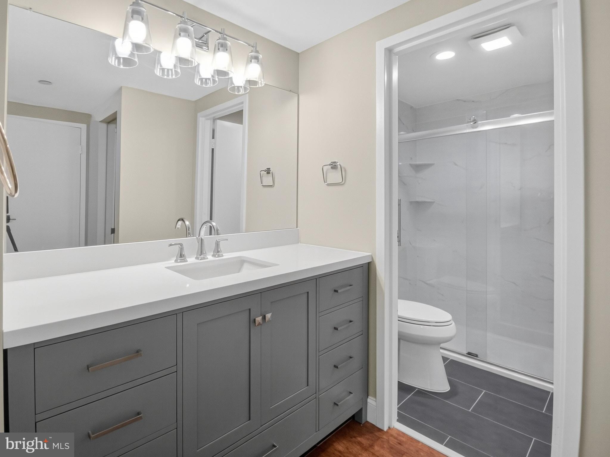 1530 Key Boulevard, Unit 517 Arlington, VA 22209 - Photo 4 of 50 a bathroom with a toilet a sink and a mirror