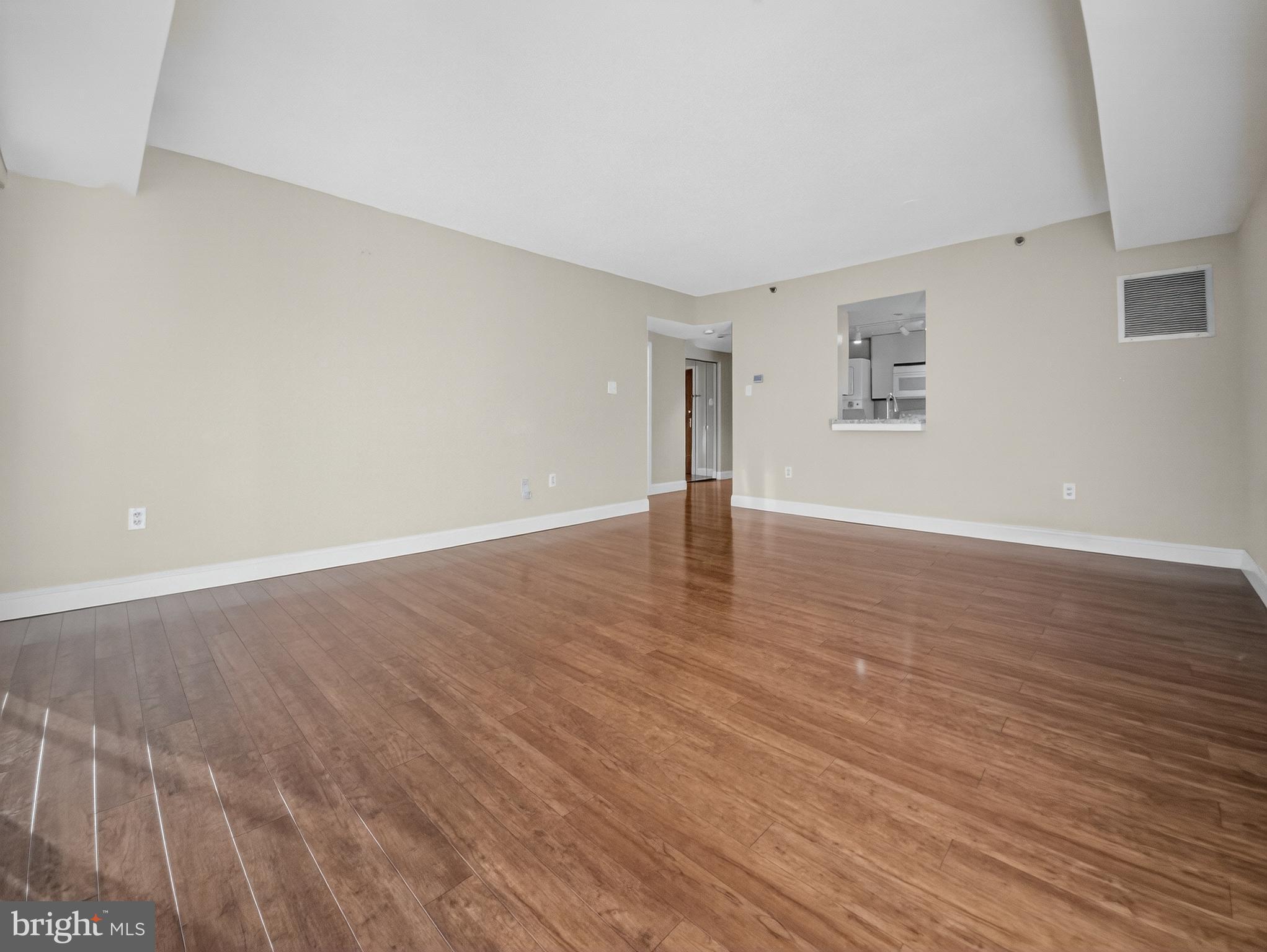1530 Key Boulevard, Unit 517 Arlington, VA 22209 - Photo 8 of 50 a view of an empty room with wooden floor and a window