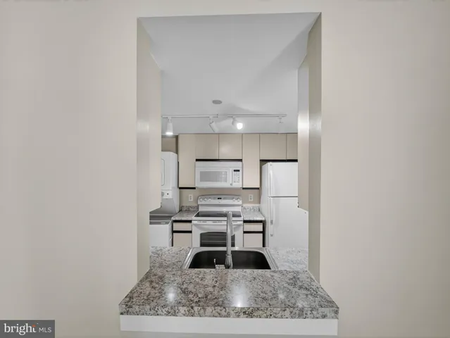 a kitchen with a refrigerator and a counter top space