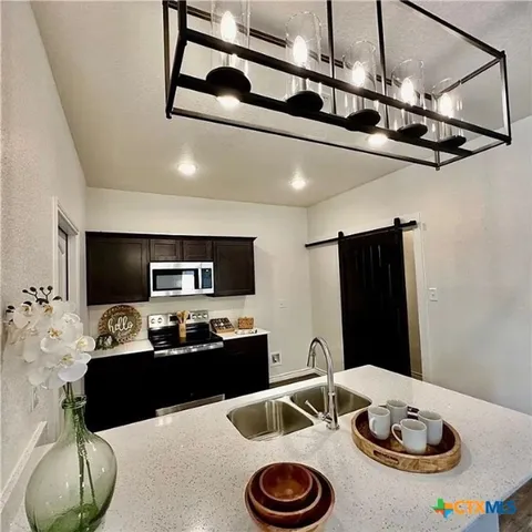a kitchen with stainless steel appliances kitchen island granite countertop a sink and cabinets