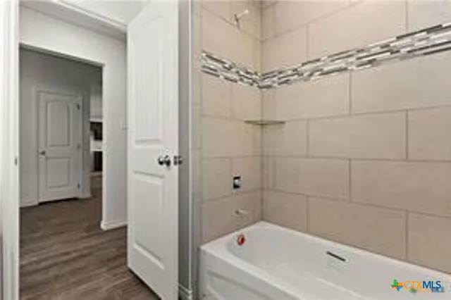 a bathroom with a bathtub a window and a shower