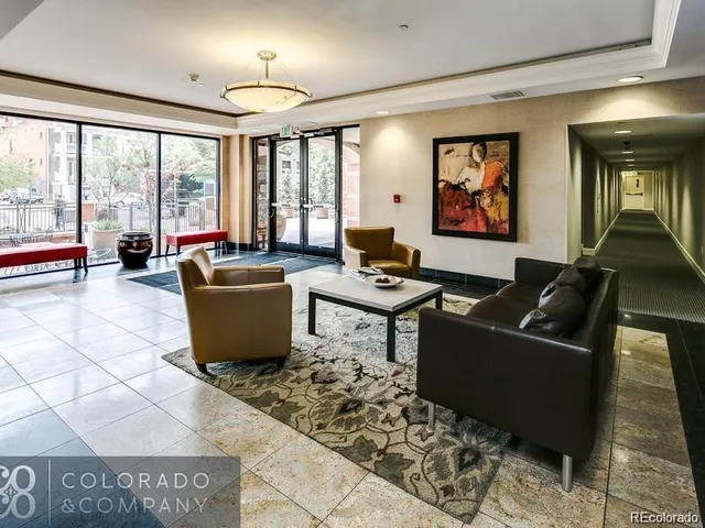 a living room with furniture a large window and a rug