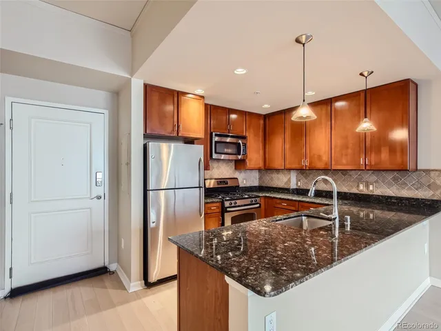a kitchen with stainless steel appliances granite countertop a sink refrigerator and microwave