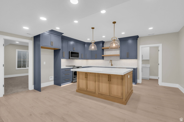 2828 Jojo Road Eagle Mountain, UT 84005 - Photo 41 of 63 Modern kitchen with blue cabinetry, white subway tile backsplash, and wood-finish flooring