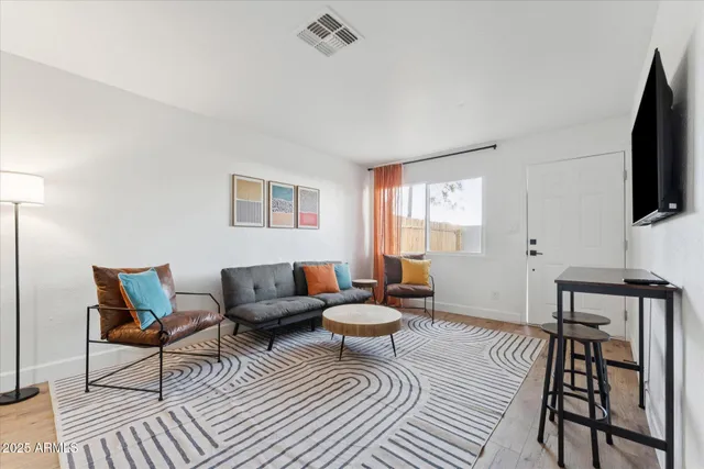 a living room with furniture a flat screen tv and a window
