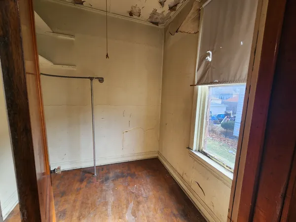 a view of a small space with wooden floor and a window
