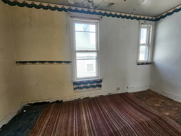 a view of a room with wooden floor and windows