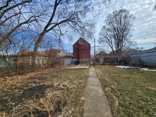 a large tree in front of a brick house