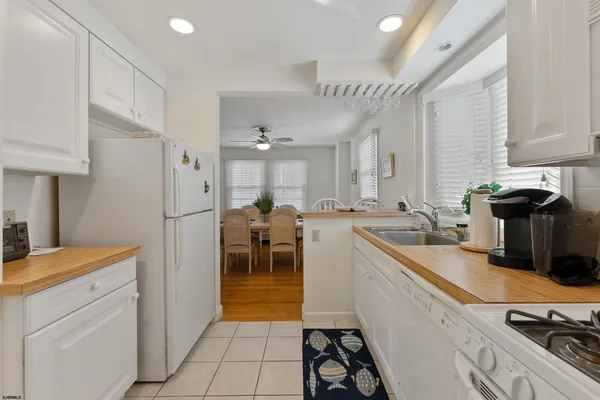 a kitchen with a sink a stove cabinets and a dining table