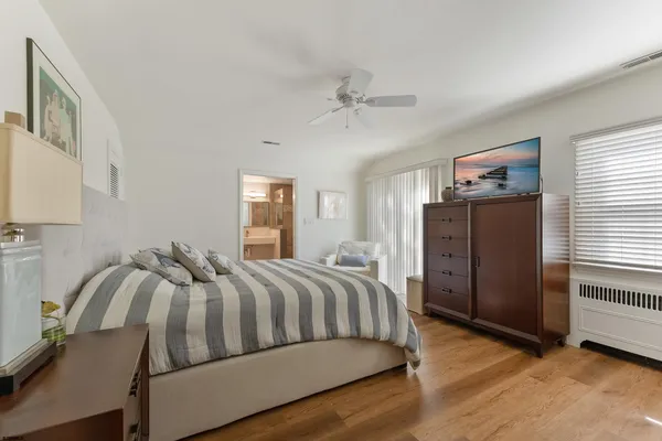 a bedroom with a bed and wooden floor