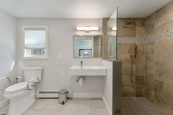 a bathroom with a sink a toilet and shower