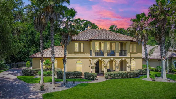 a front view of a house with a garden and plants