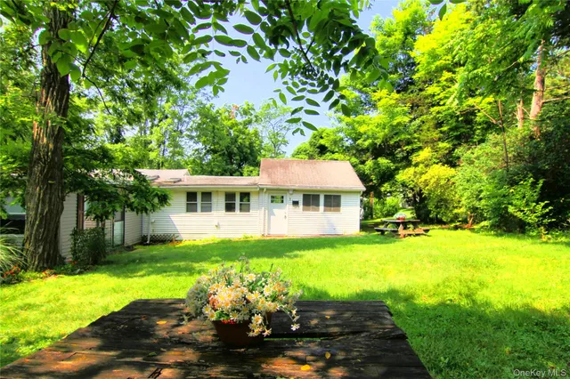 a view of a house with a yard and sitting area