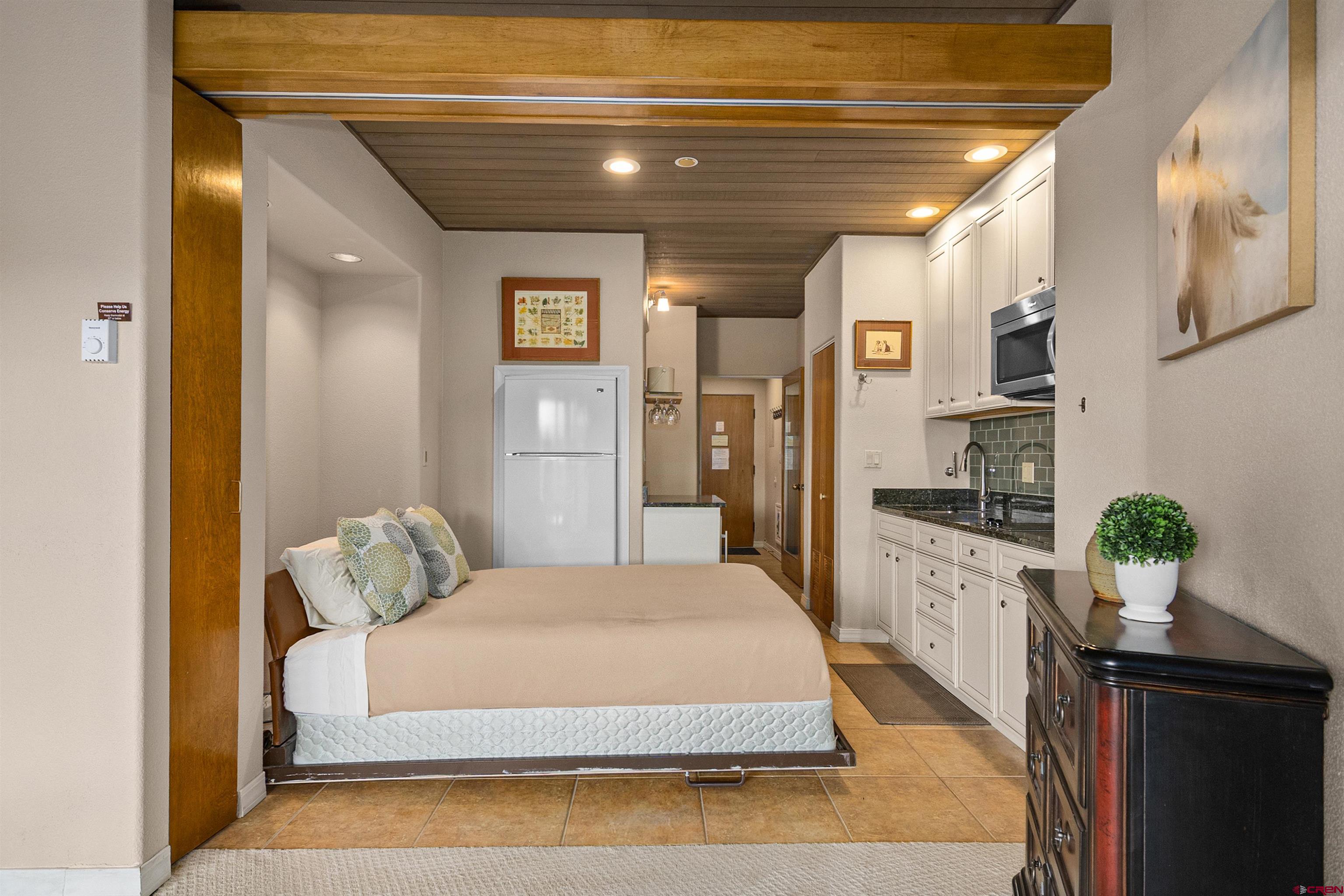 117 Needles Way, Unit 423 Durango, CO 81301 - Photo 17 of 37 a spacious bedroom with a bed and wooden floor
