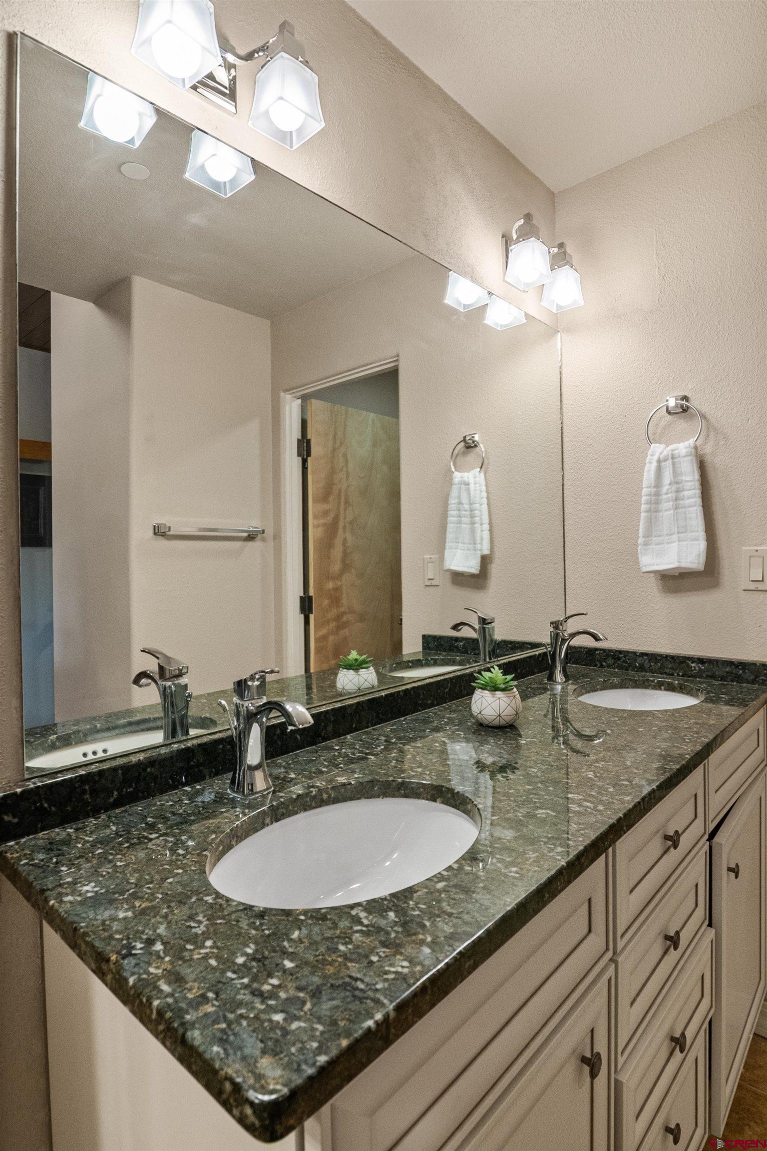 117 Needles Way, Unit 423 Durango, CO 81301 - Photo 21 of 37 a bathroom with a granite countertop double vanity sinks and a mirror