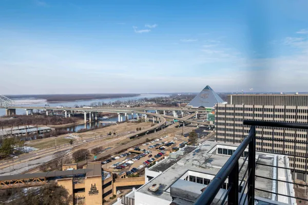 an empty room with wooden floor and windows with curtains