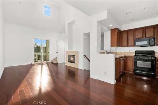 a kitchen with stainless steel appliances granite countertop a stove top oven a sink and a wooden floors