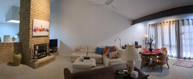 a living room with furniture a fireplace and a large window