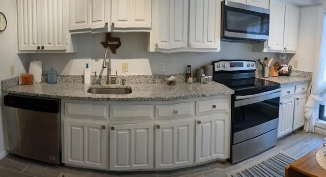 a kitchen with stainless steel appliances granite countertop a sink stove and cabinets
