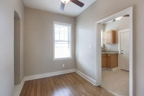 a view of an empty room with window and wooden floor