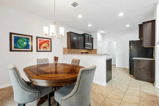 a kitchen with stainless steel appliances granite countertop a sink a microwave and chairs