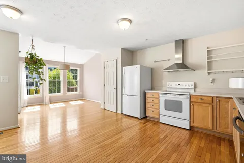 a kitchen with granite countertop a stove a sink and a refrigerator