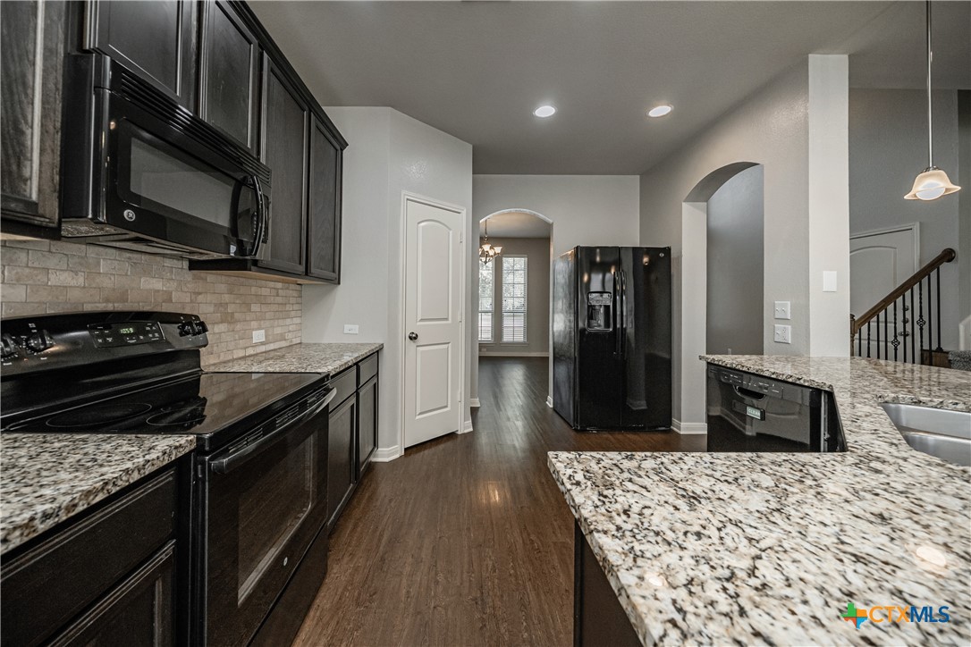 7848 Old Gate Road Temple, TX 76502 - Photo 15 of 32 a kitchen with stainless steel appliances granite countertop a stove refrigerator and microwave