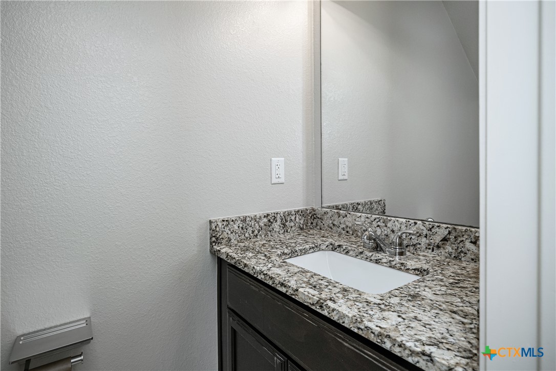 7848 Old Gate Road Temple, TX 76502 - Photo 18 of 32 a bathroom with a granite countertop sink and a white stove