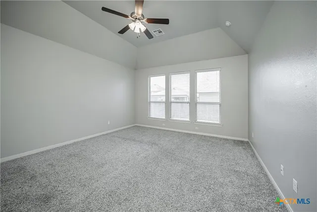 an empty room with a window and a fan