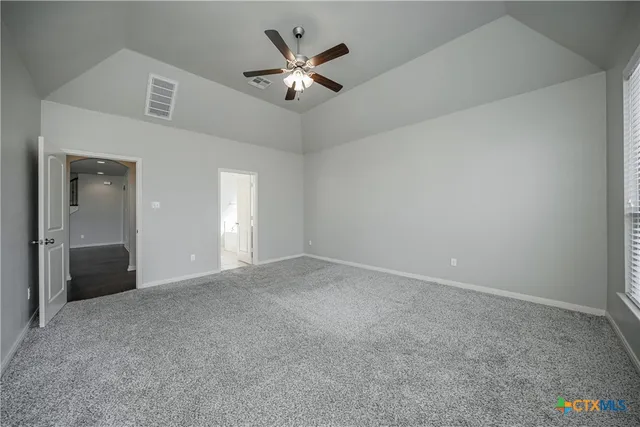 an empty room with fan and windows
