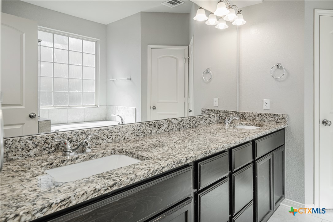 7848 Old Gate Road Temple, TX 76502 - Photo 21 of 32 a bathroom with a granite countertop sink and a mirror