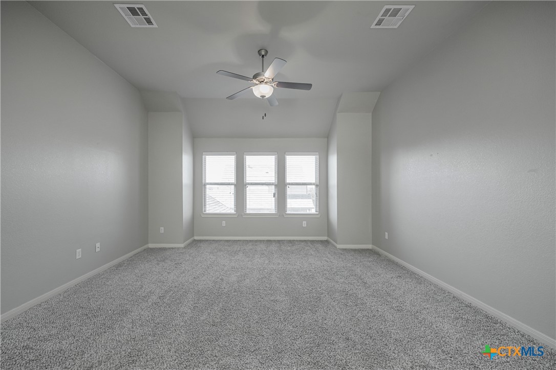 7848 Old Gate Road Temple, TX 76502 - Photo 24 of 32 an empty room with chandelier fan and windows