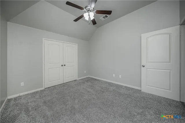 a view of an empty room and a ceiling fan