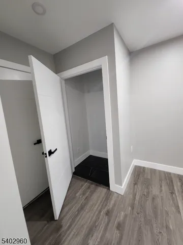 an entryway space with wooden floor and staircase