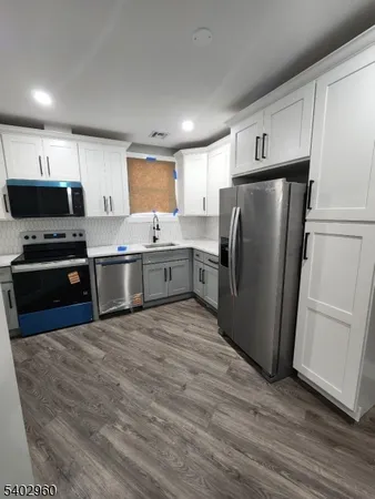 a kitchen with stainless steel appliances granite countertop a refrigerator a sink and a stove