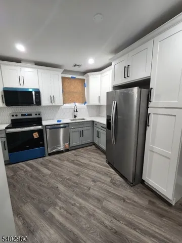 a kitchen with stainless steel appliances granite countertop a refrigerator a sink and a stove