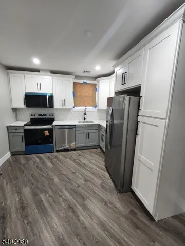 a kitchen with stainless steel appliances a refrigerator sink and microwave