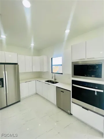a kitchen with stainless steel appliances a stove a sink and a refrigerator
