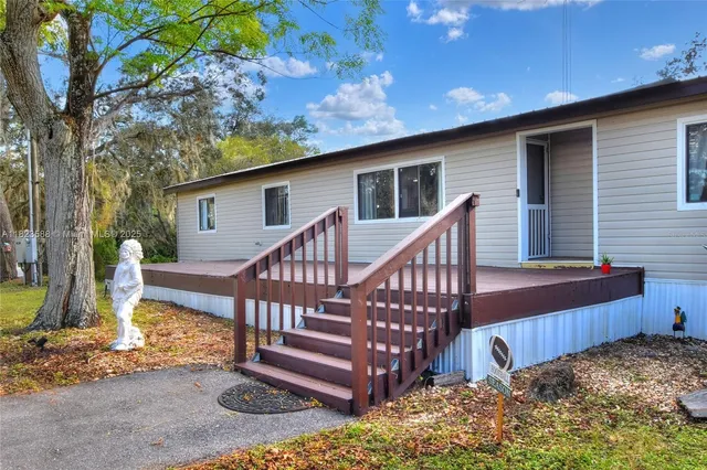 a view of a house with backyard and a tree