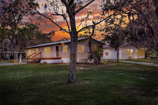 a view of a house with yard and tree s