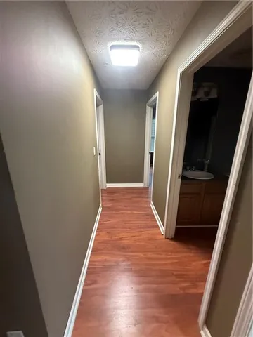 a view of hallway with stairs and wooden floor