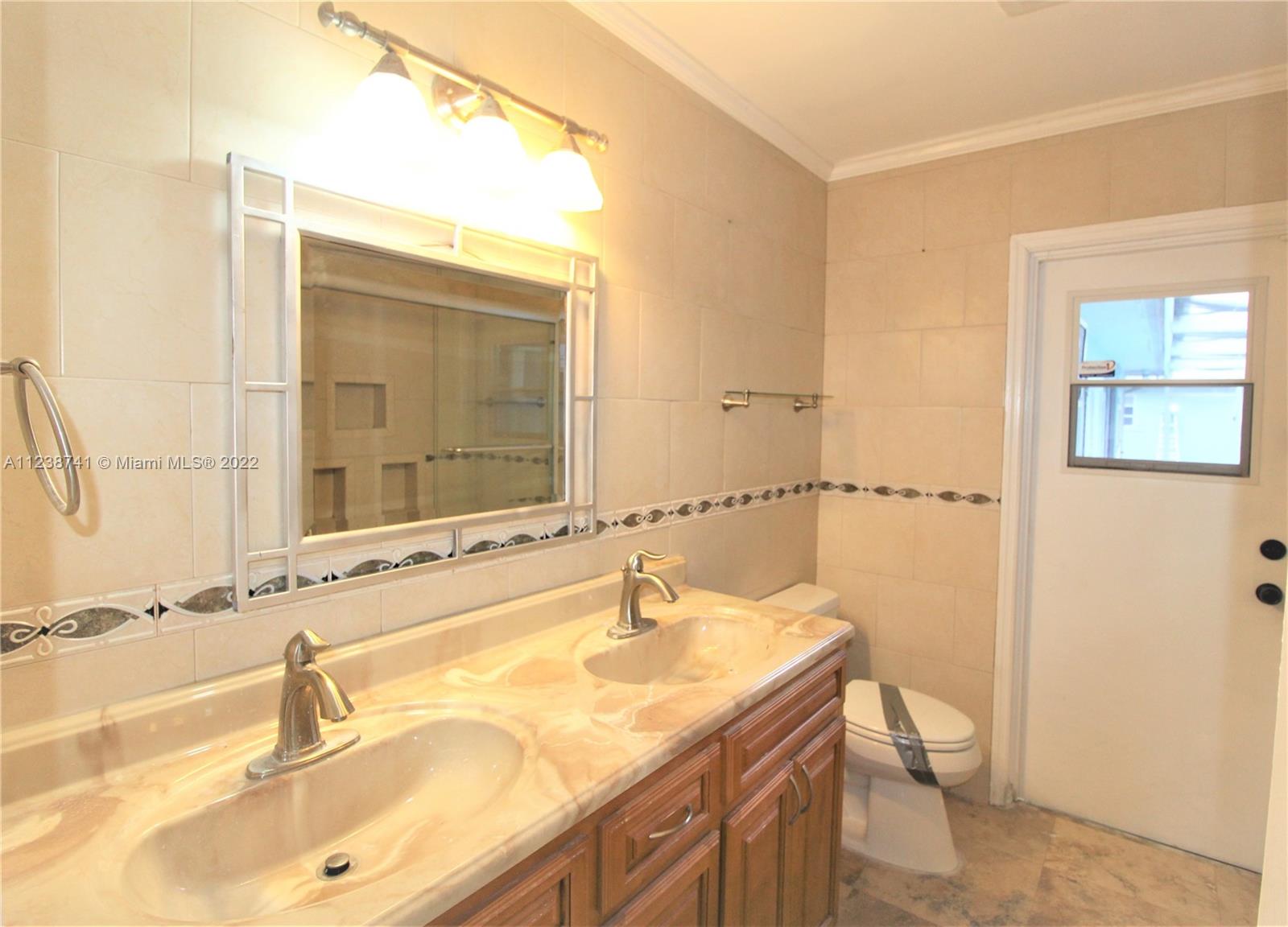 5261 Southwest 9th Street Plantation, FL 33317 - Photo 11 of 27 a bathroom with a sink and a mirror