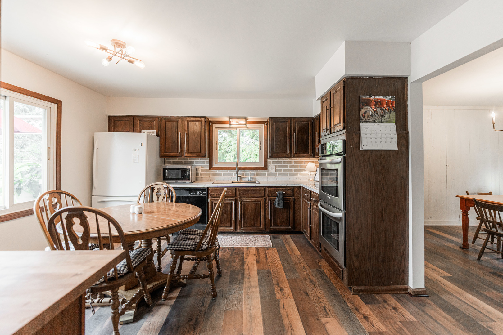 17751 Scott Road Hinckley, IL 60520 - Photo 21 of 72 a kitchen with granite countertop a refrigerator a stove a sink a dining table and chairs with wooden floor